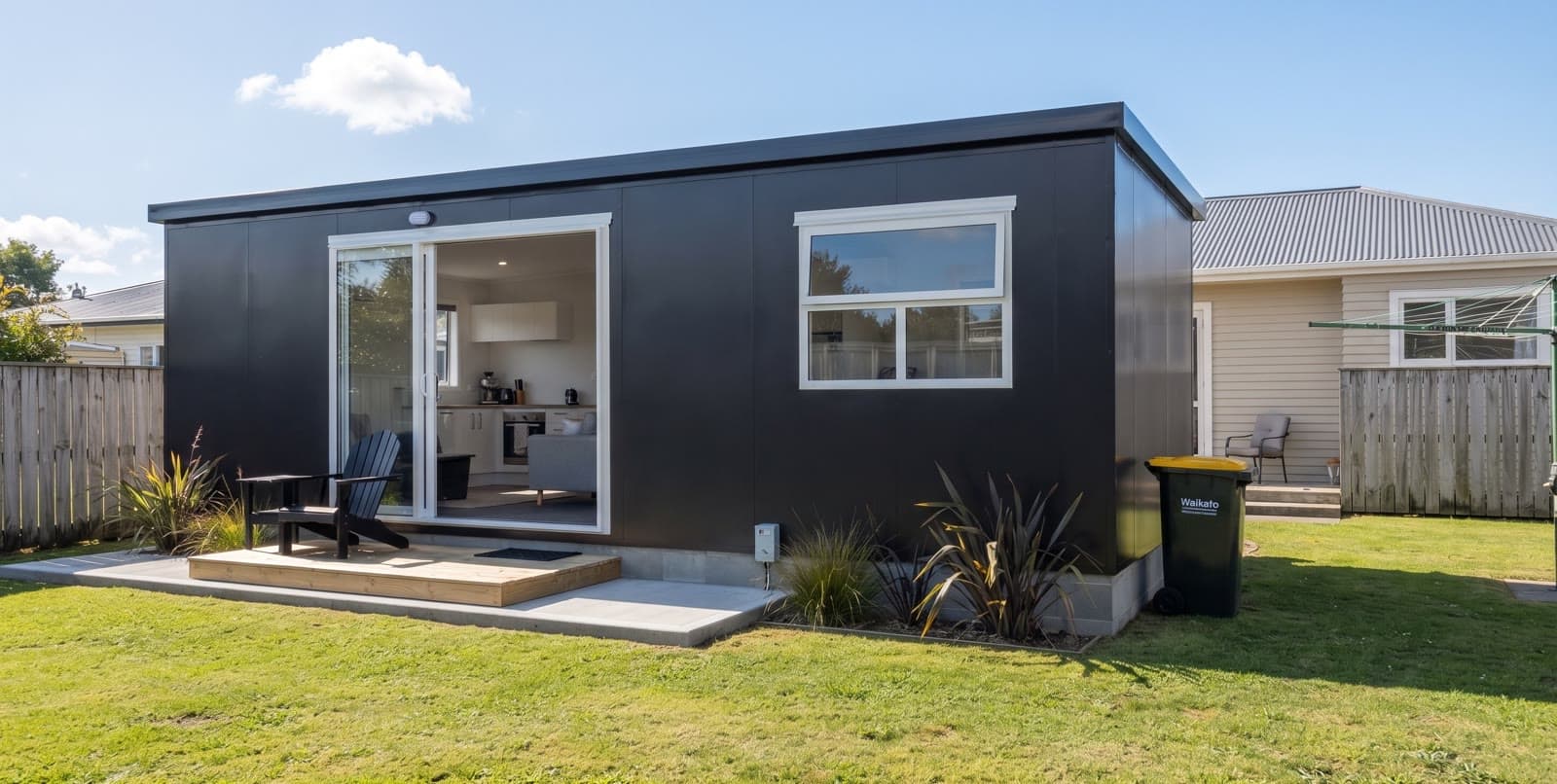 Black 8×3 economy one-bedroom tiny home on a timber deck